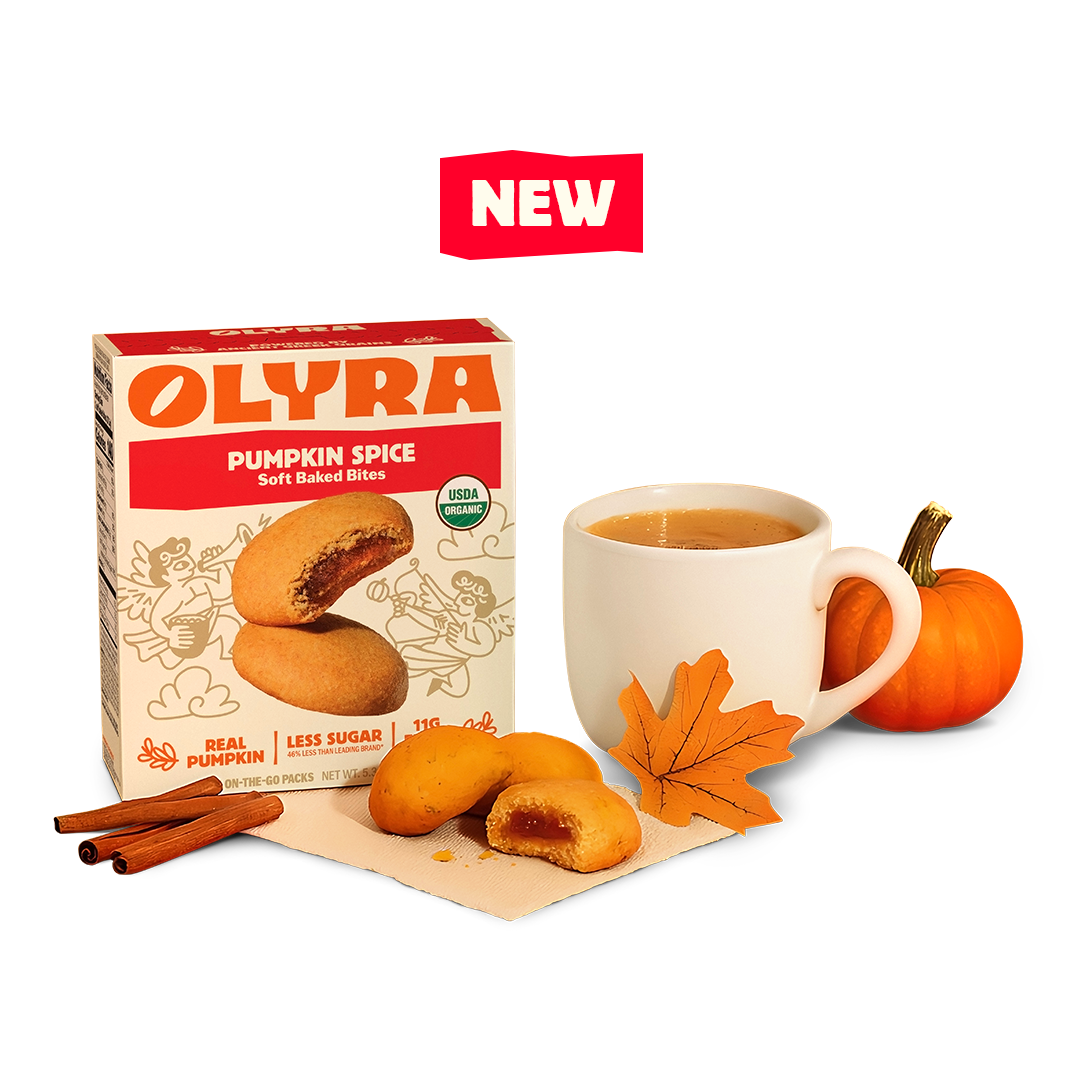 Olyra pumpkin spice bites with a cup of coffee, cinnamon sticks, and a small pumpkin on a white background.