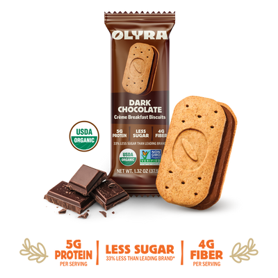 Olyra Dark Chocolate Creme Breakfast Biscuits packaging with a single biscuit and chocolate pieces on a white background.