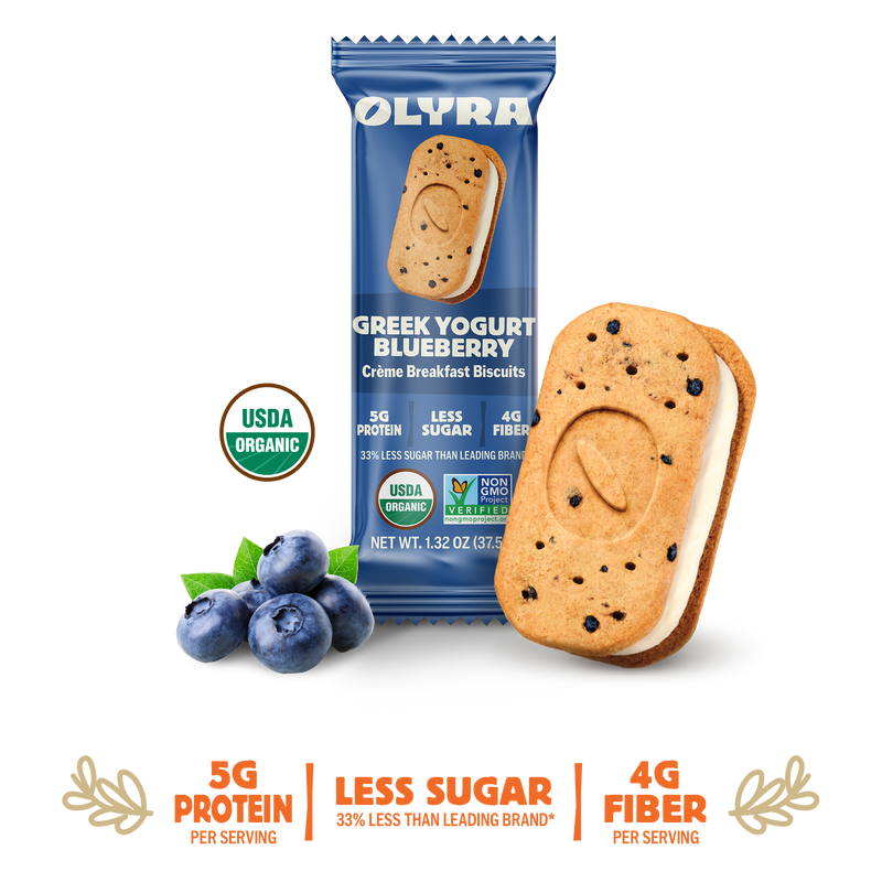 Olyra Greek Yogurt Blueberry cookie with packaging and blueberries on a white background