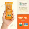 Hand holding a package of Olyra Cinnamon Tahini breakfast biscuits with product details and sustainability information.