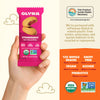 Olyra strawberry soft baked bites packaging held by a hand with product details on an orange background.