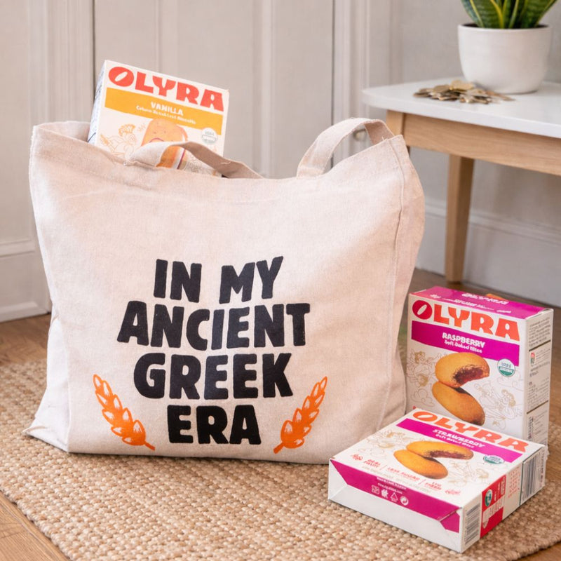 Tote bag with 'In my ancient Greek era' text and Olyra boxes surrounding it.